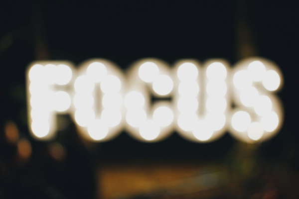 Blurry photograph of the word FOCUS spelled in lights