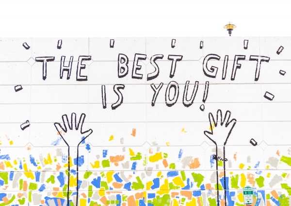 Large mural on white wall that says The Best Gift Is You!